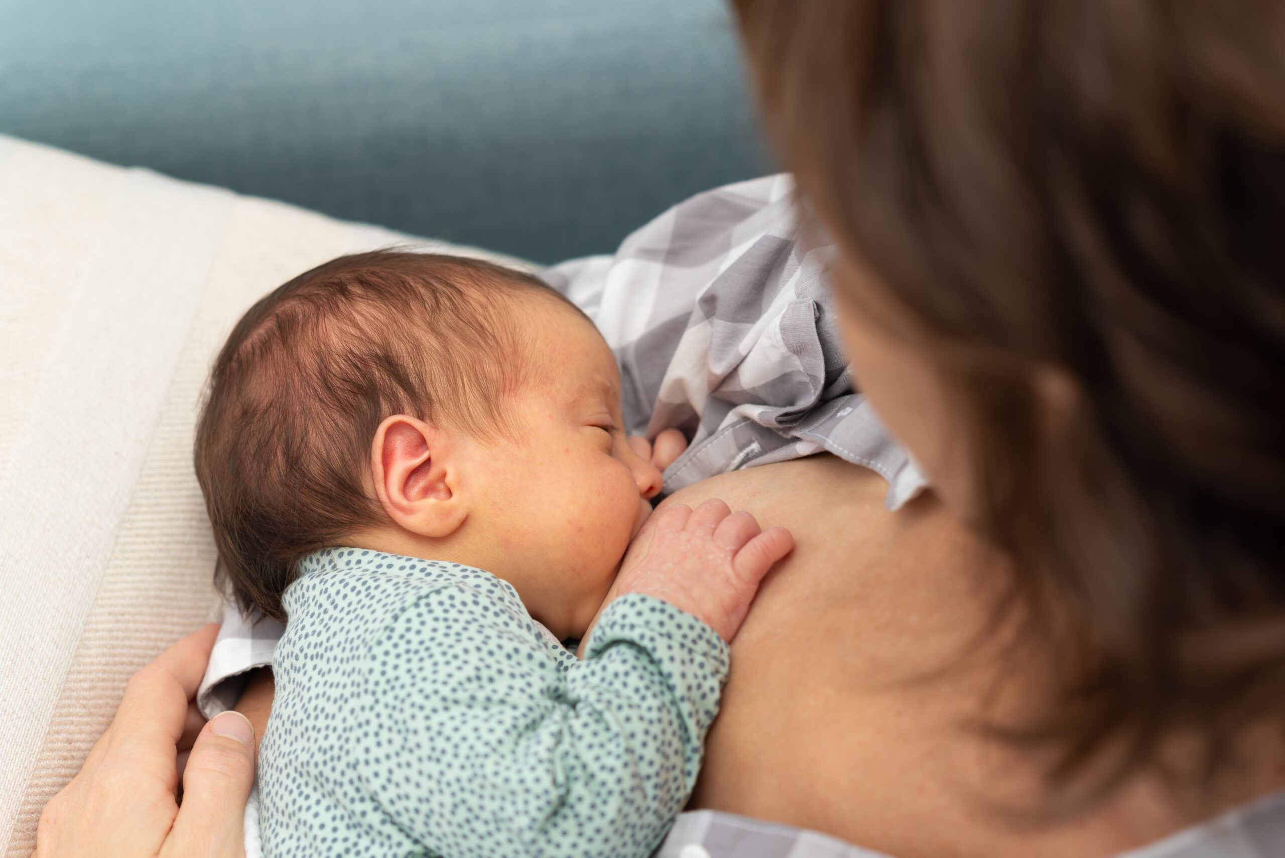 Overhead view of a woman breastfeeding her infant, a process made easier after correcting her inverted nipples with surgery